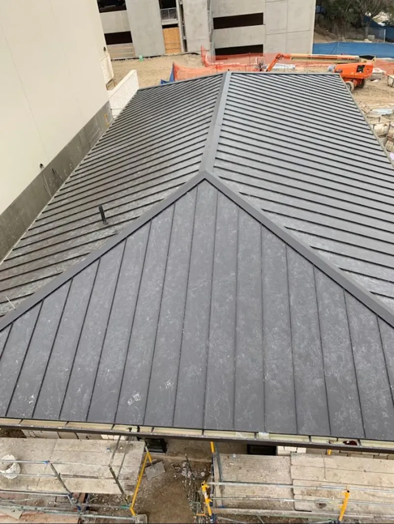 Commercial metal roof construction with crane equipment in Tillmans Corner